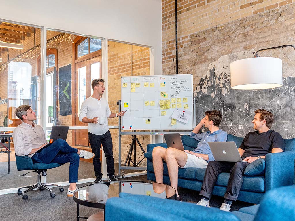 A marketing strategy meeting in front of a whiteboard | Work with a team of content marketing strategists from Shizzle Marketing
