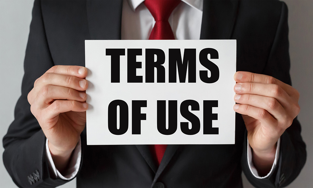 A person holding a piece of paper showing Terms of Use.